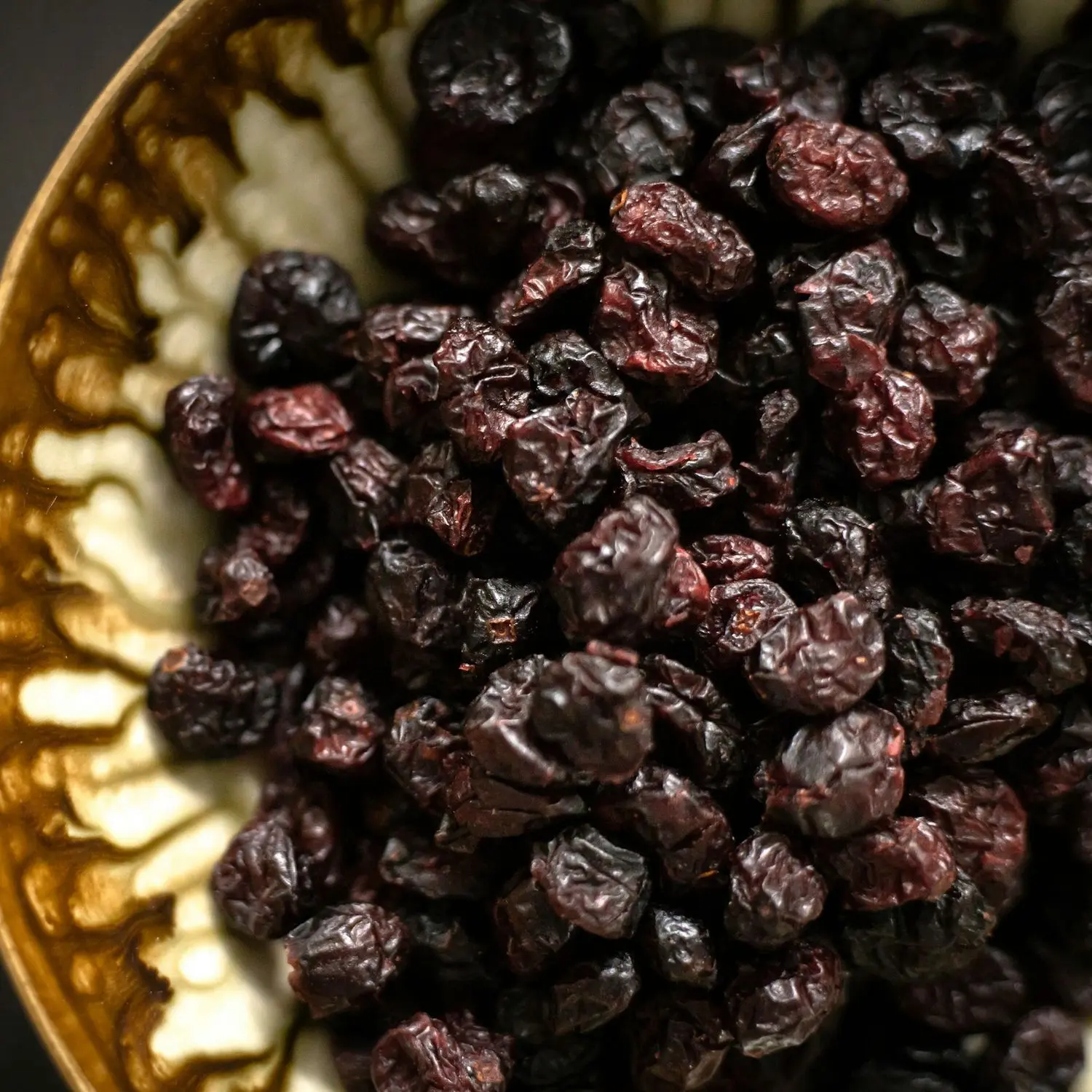 Black raisins in a brass bowl