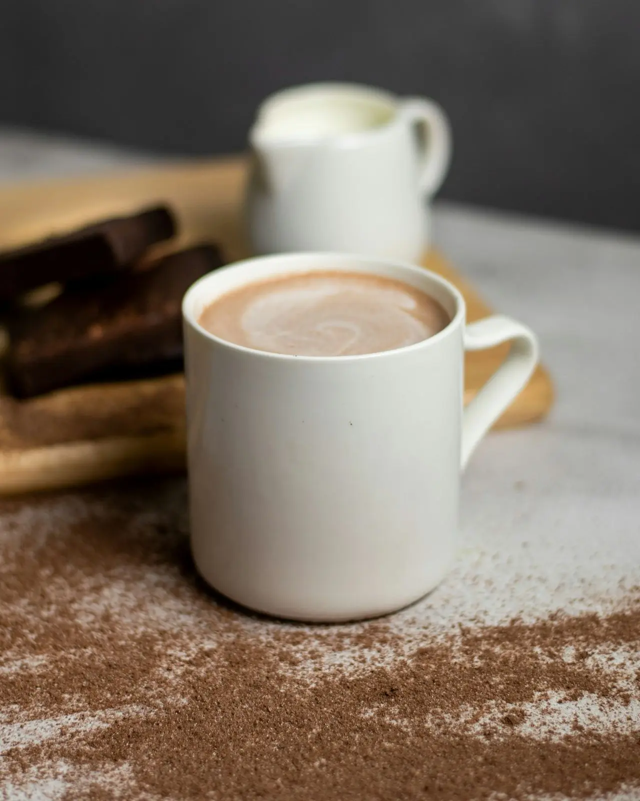 Mug of milky chocolate tea with chocolate pieces