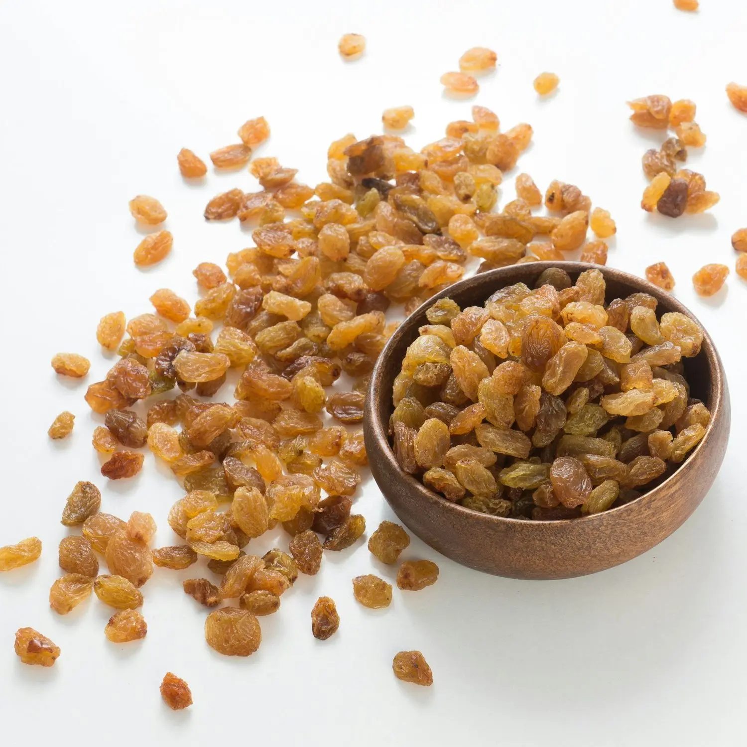 Golden seedless raisins in a wooden bowl