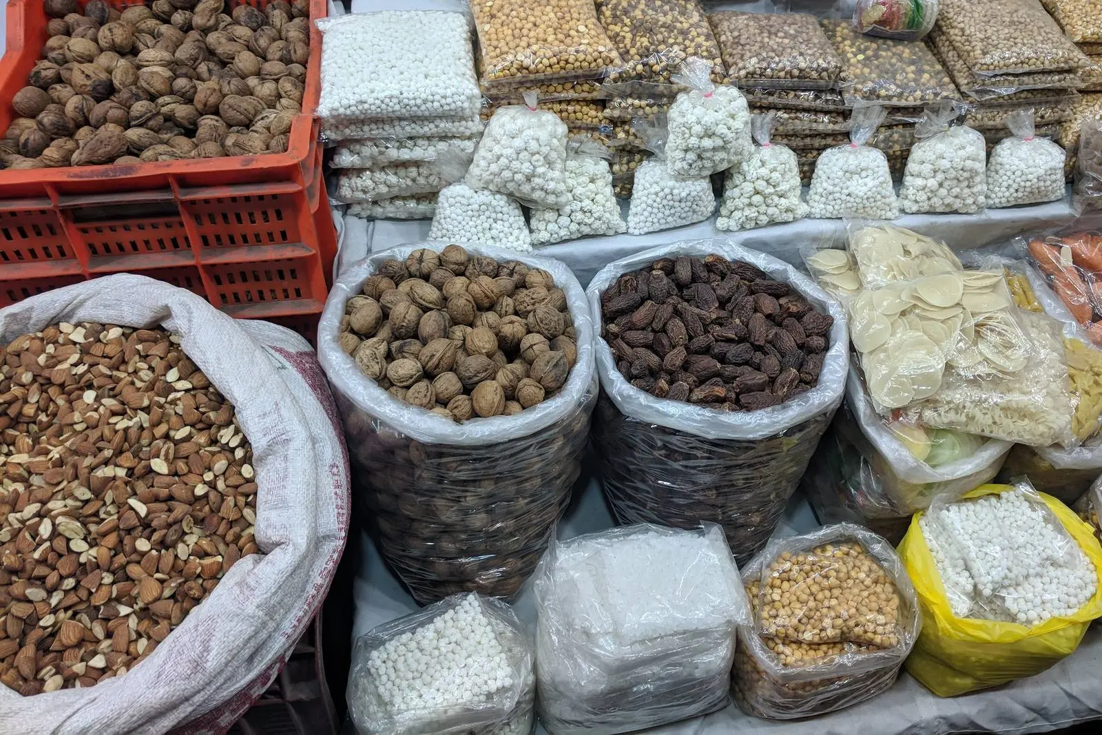 Sacks of almonds, walnuts and dates on display at a dry fruits shop